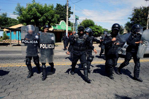 Riot police move against journalists at the entrance to police headquarters in Managua, Nicaragua, Dec. 15, 2018. (Reuters/Oswaldo Rivas)