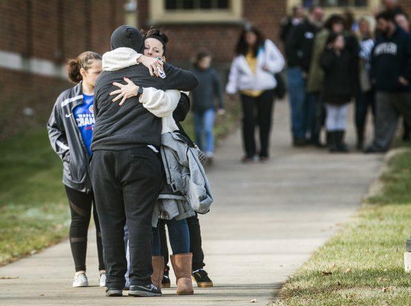 Families are reunited with their children at the Civic Hall Performing Arts Center where students waited after being bussed from Dennis Intermediate School following a shooting in Richmond, Ind., on Dec. 13 2018. (Jordan Kartholl/The Palladium-Item via AP)