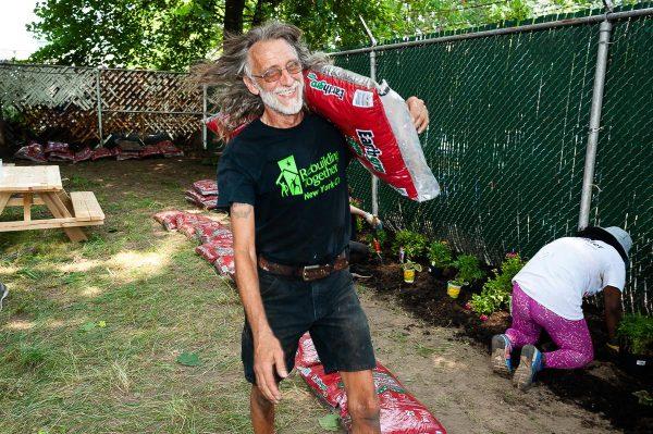 Terry Scott hauling a bag of mulch. (Courtesy of Rebuilding Together NYC)