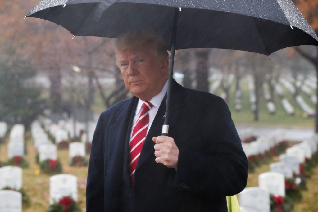 President Donald Trump holds an umbrella during an unscheduled visit to Arlington National Cemetery in Arlington, Virginia on Dec. 15, 2018. (ROBERTO SCHMDIT/AFP/Getty Images)
