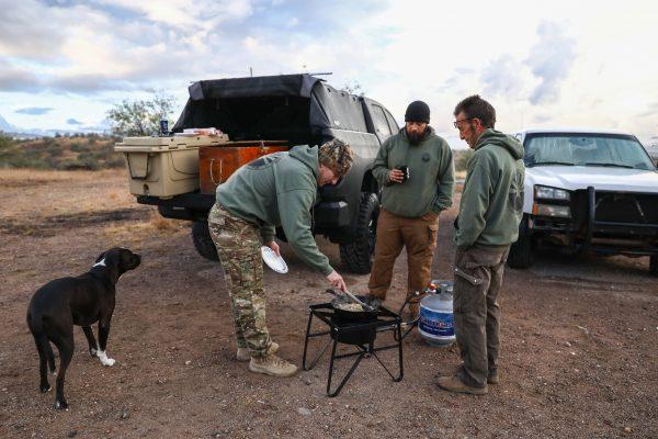 Ryan (L) and Randon cook breakfast with Arizona Border Recon founder Tim Foley (R) before they head out to surveil the U.S.–Mexico border, in Arivaca, Ariz., on Dec. 7, 2018. Charlotte Cuthbertson/The Epoch Times)
