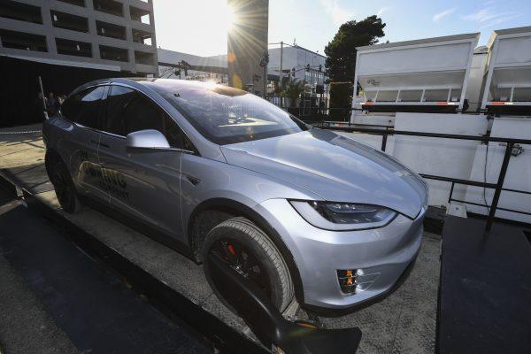 A modified Tesla Model X rests on an elevator above the pit and tunnel entrance before an unveiling event for the Boring Company Hawthorne test tunnel in Hawthorne, Calif., on Dec. 18, 2018. (Robyn Beck/Pool Photo/AP)