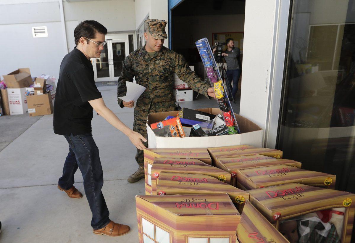 Sgt. Christian Pastrana, right, prepares toys for a donation to the organization Women in Distress, at the Marine Corps Toys for Tots depot, on Dec. 19, 2018, in Hialeah, Fla. (AP Photo/Lynne Sladky)