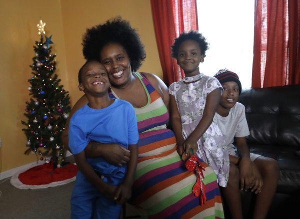 Keiondra Ross poses with her children Kaydan Lawson, left, Kayla Lawson, and Daniel Lawson, right, at their home in Miami, on Dec. 19, 2018. (Lynne Sladky/AP Photo)