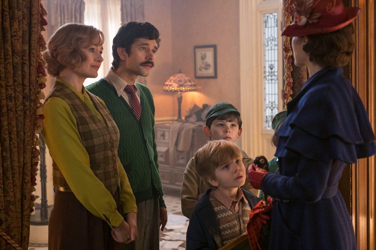 (L–R) Jane (Emily Mortimer), Michael (Ben Whishaw), John (Nathanael Saleh), and Georgie (Joel Dawson) greet Mary Poppins (Emily Blunt) upon her return to the Banks's home. (Disney)