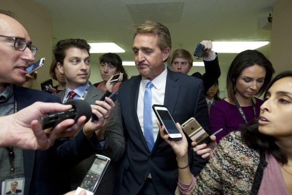 Sen. Jeff Flake (R-Ariz.) a member of the Senate Foreign Relations Committee, speaks with reporters on his way to the senate chamber at the Capitol in Washington, on Dec. 21, 2018. (AP Photo/Jose Luis Magana)