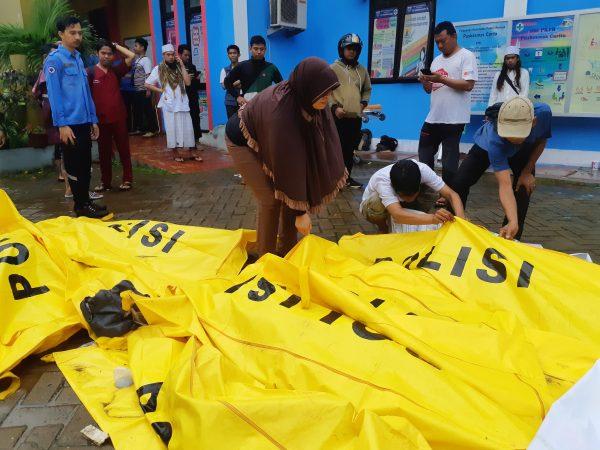 Residents inspect body bags as they search for family members outside a local health center following a tsunami at Panimbang district in Pandeglang, Banten province, Indonesia, Dec. 23, 2018. (Reuters/Adi Kurniawan)