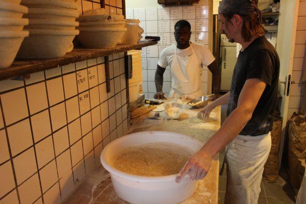 Maxime Bussy (R) and his apprentice, Mamadou Dabo, prepare to knead the dough. (Alexia Luquet/Special to The Epoch Times)