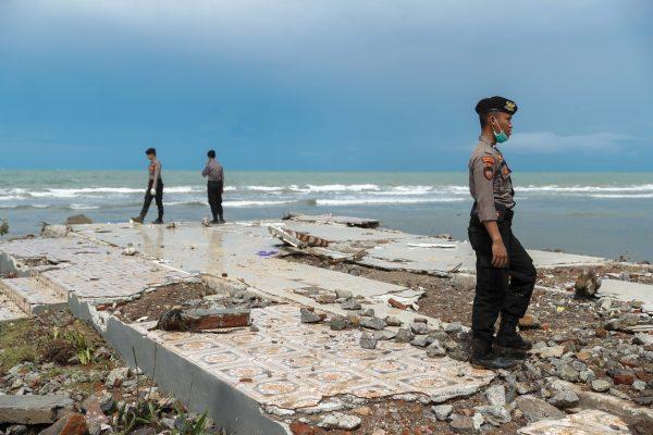 Police officers search for victims among rubble of a destroyed beach front hotel which was hit by a tsunami in Pandeglang, Banten province, Indonesia, on Dec. 24, 2018. (Reuters/Jorge Silva)