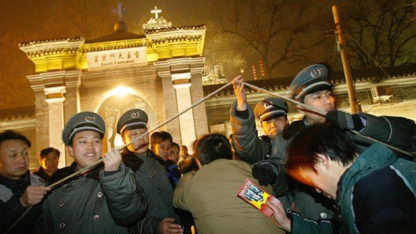 Chinese Catholics walk through a security checkpoint outside a government-approved Catholic church in Beijing, on Dec. 24, 2007. (Teh Eng Koon/AFP via Getty Images)