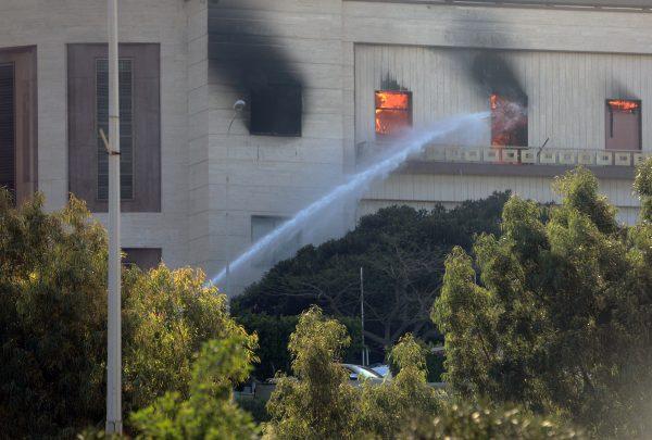 Firemen hose down a burning building of the headquarters of Libya's foreign ministry after suicide attackers hit in Tripoli, Libya, Dec. 25, 2018. (Reuters/Hani Amara)