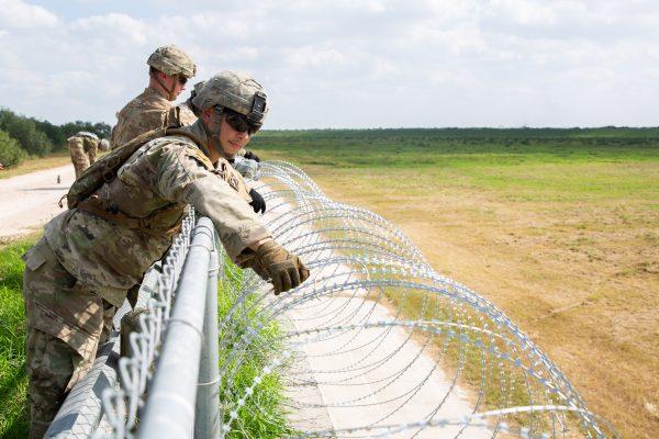 The U.S. military installs concertina wire on the levee behind Granjeno in Texas, just north of the U.S.–Mexico border on Nov. 7, 2018. (Samira Bouaou/The Epoch Times)