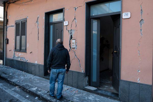 A resident stands near a cracked building in Zafferana Etnea near Catania on Dec. 26, 2018. (Giovanni Isolino/AFP/Getty Images)