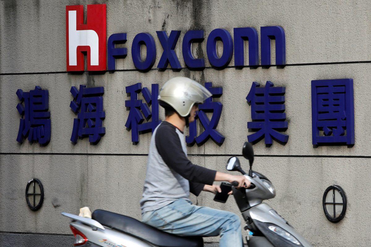 A motorcyclist rides past the logo of Foxconn, the trading name of Hon Hai Precision Industry, in Taipei, Taiwan on March 30, 2018. (Tyrone Siu/Reuters)