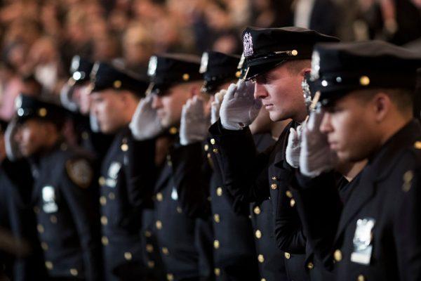 The newest members of the New York City Police Department (NYPD) salute during their police academy graduation ceremony at the Theater at Madison Square Garden in New York City on March 30, 2017. (Drew Angerer/Getty Images)