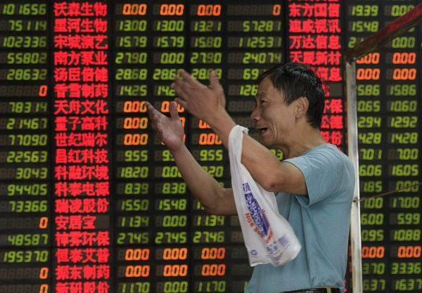 An investor reacts in front of screens showing stock market movements at a brokerage house in Shanghai on Sept. 1, 2015. (Johannes Eisele/AFP/Getty Images)