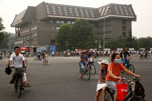 People cycle past a Peking University building in Beijing, China on July 27, 2016. (Thomas Peter/Reuters)