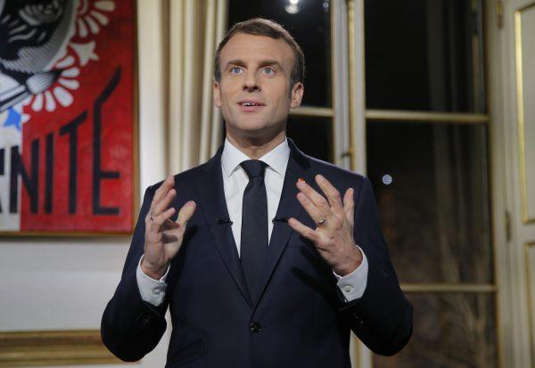 French President Emmanuel Macron gestures as he delivers his New Year wishes during a televised address to the nation from the Elysee Palace in Paris on Dec. 31, 2018. (Michel Euler/AFP/Getty Images)