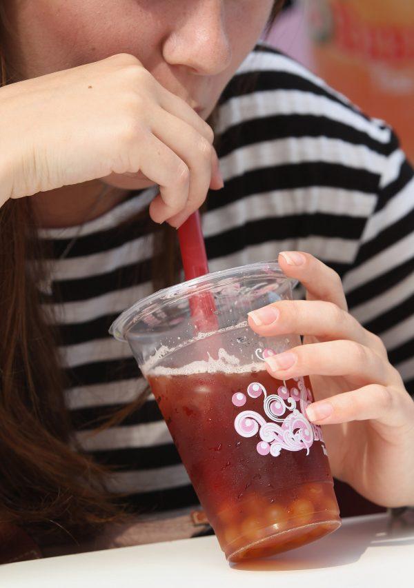 A young woman sips bubble tea outside a bubble tea cafe on August 22, 2012 in Berlin, Germany. Bubble tea, which fuses Asian tea with milk or fruit syrups and sometimes contains balls of tapioca, originated in Taiwan and has most recently spread in popularity to North America and Europe. (Sean Gallup/Getty Images)