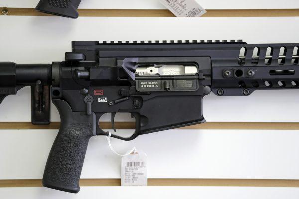 A semi-automatic rifle, with "God Bless America" imprinted on it, is displayed for sale on the wall of a gun shop in Lynnwood, Wash., on Oct 2, 2018. (Elaine Thompson/AP)