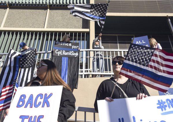 People hold flags and signs on Jan. 2, 2019, outside the Stanislaus County Superior courthouse in Modesto, Calif., where formal charges were filed against Gustavo Perez Arriaga. (Andy Alfaro/The Modesto Bee/AP)