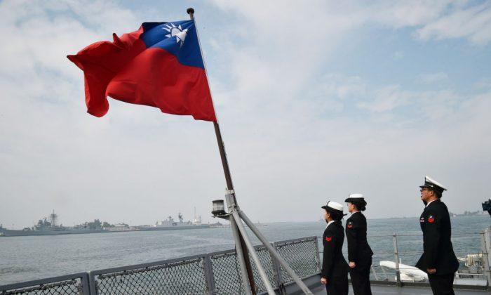 Sailors salute the island's flag on the deck of the Panshih supply ship at the Tsoying naval base in the southern city of Kaohsiung, Taiwan, on Jan. 31, 2018. (Mandy Cheng/AFP/Getty Images)