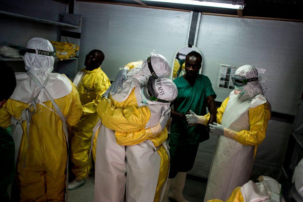 Health workers embrace while putting on their personal protective equipment before heading into an ebola treatment centre in Bunia, Democratic Republic of Congo, on Nov. 7, 2018. (John Wessels/AFP)