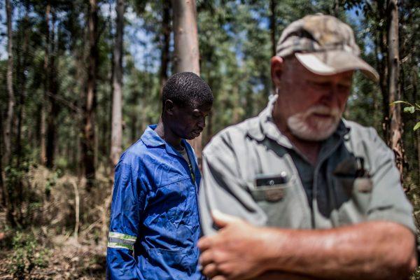 Farm worker Mogoala Justice Ratalele (L) stands near his employer Hans Bergmann after an incident in which he was held at gunpoint for the theft of the chainsaw that he was working with, on Nov. 2, 2017, in Tzaneen, South Africa. A long campaign of violence against the country's farmers, who are largely white, has inflamed political and racial tensions nearly a quarter-of-a-century after the fall of apartheid. (Gulshan Khan/AFP/Getty Images)