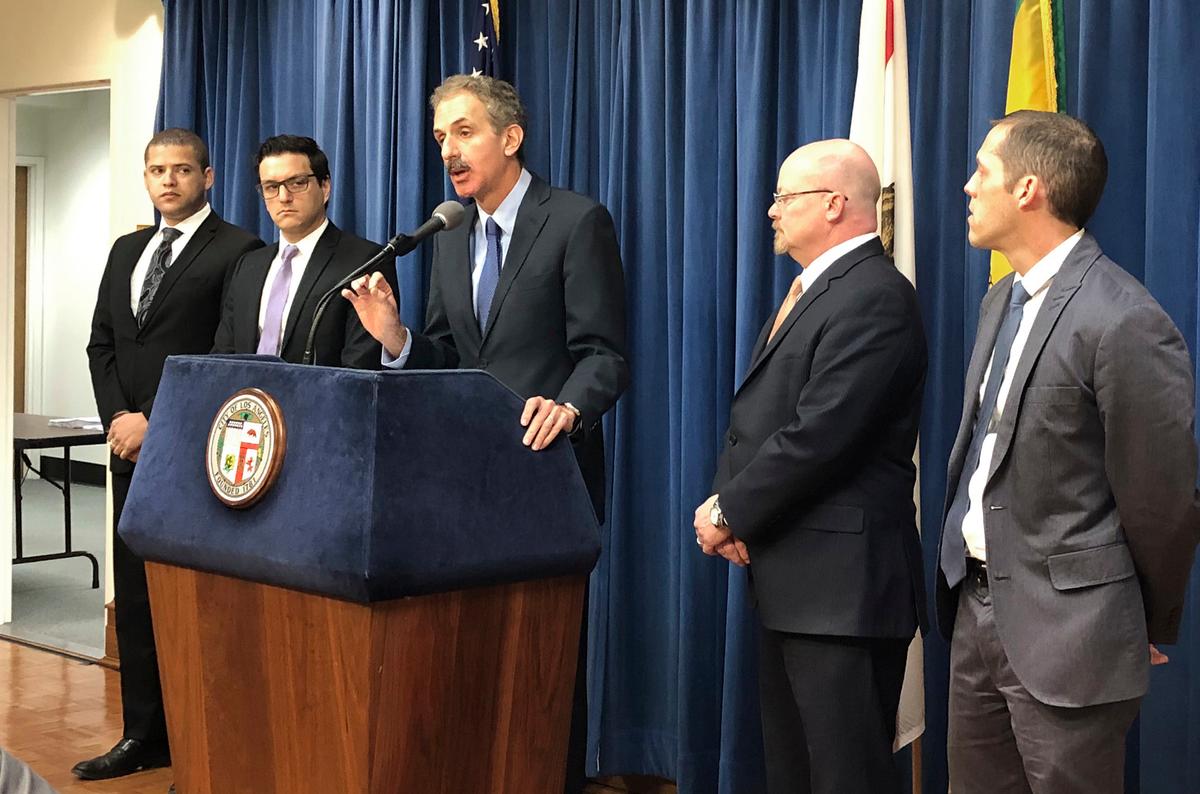Los Angeles City Attorney Mike Feuer, at podium, speaks at a news conference in Los Angeles Friday, Jan. 4, 2019. Feuer said the company misled users of the popular app to think their location data will only be used for personalized forecasts and alerts. (Brian Melley/AP)