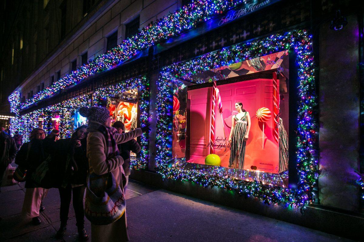 People stop to look at holiday window displays at the Saks Fifth Avenue store in New York City on Dec. 20, 2016. (Benjamin Chasteen/Epoch Times)