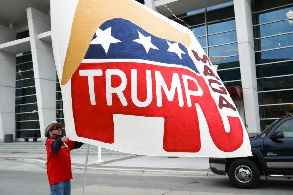 Will Schimmels waves a giant, handmade flag outside a Make America Great Again rally in Rochester, Minn., on Oct. 4, 2018. (Charlotte Cuthbertson/The Epoch Times)