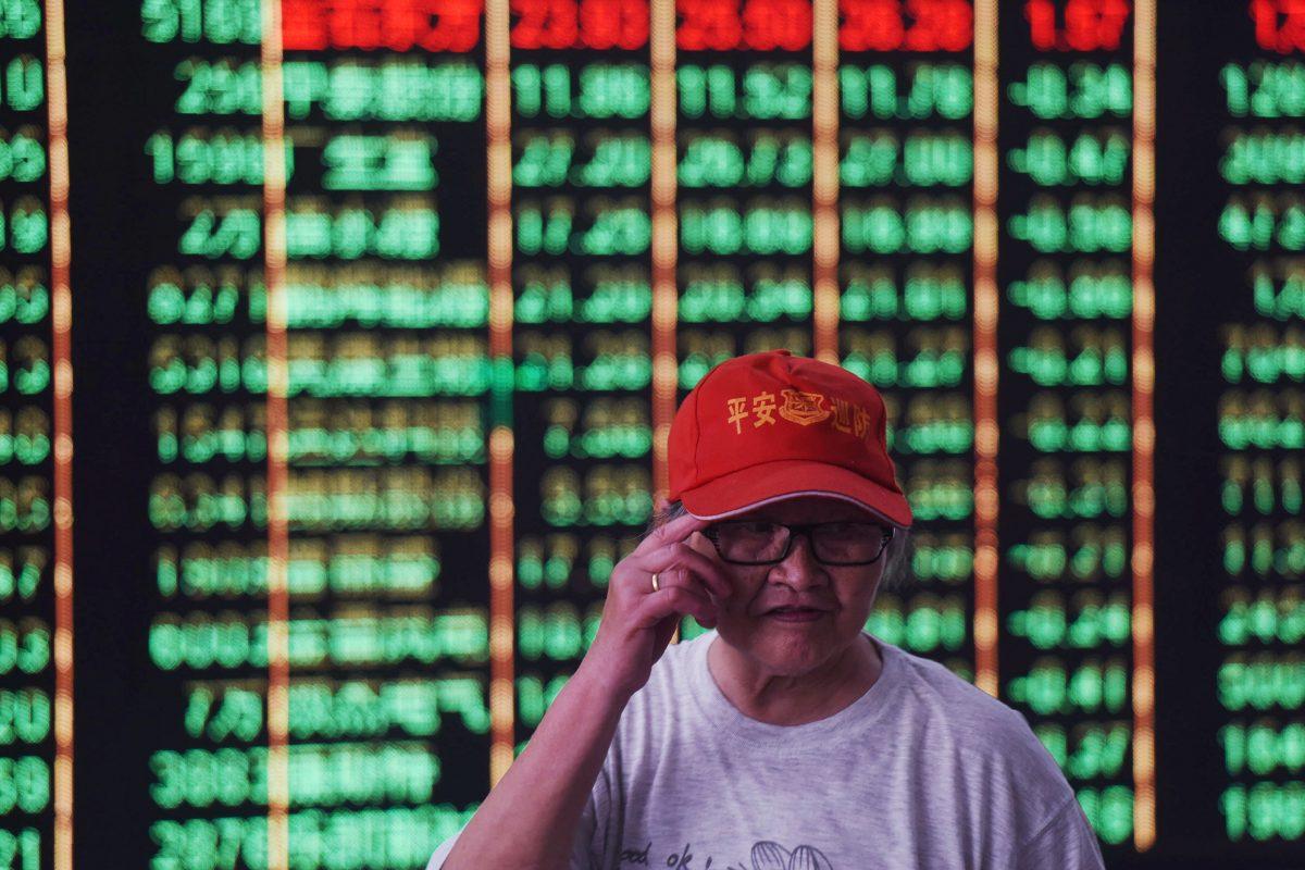 An investor stands in front of a screen displaying stock market figures at a securities company in Hangzhou in China's Zhejiang Province on June 19, 2018. Shanghai and Hong Kong stocks plunged on June 19 on investors' fears that the U.S. and China could be heading for a full-blown trade war following tit-for-tat tariff threats. (AFP/Getty Images)