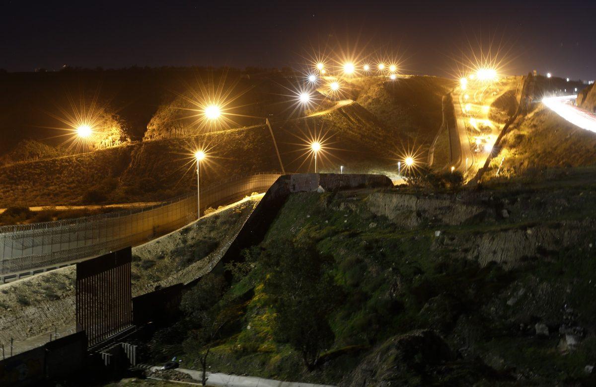 Floodlights from the United States illuminate multiple border walls on Jan. 7, 2019, as seen from Tijuana, Mexico. (Gregory Bull/AP Photo)