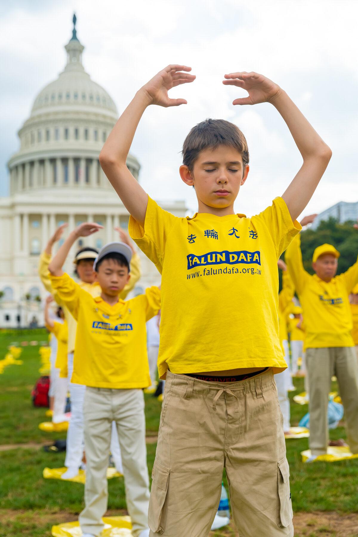 Falun Gong practitioners perform the exercises at a rally commemorating the 20th anniversary of the persecution of Falun Gong in China, on the West Lawn of Capitol Hill, on July 18, 2019. (Mark Zou/The Epoch Times)