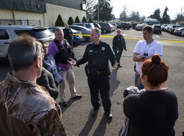 Eugene Police Sgt. Ryan Molony, center, talks to parents outside Cascade Middle School in Eugene, Ore., on Jan. 11, 2019. (Chris Pietsch/The Register-Guard/AP)