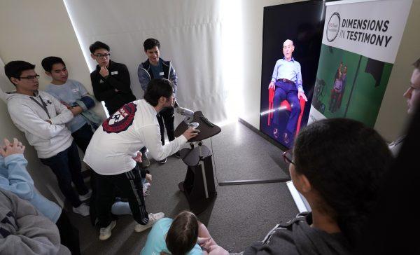 Matthew Rosca-Halmagean, 17, center, a student at Westchester Academy for International Studies, asks a question to Holocaust survivor William Morgan using an interactive virtual conversation exhibit at the the Holocaust Museum Houston in Houston on Jan. 11, 2019. (David J. Phillip/AP)