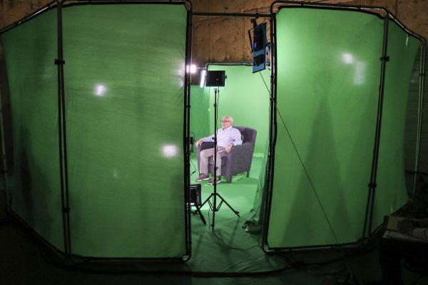 This August 2018 photo shows Holocaust survivor Max Glauben sitting in an interactive green screen room while filming a piece for the Dallas Holocaust Museum in Dallas. (McGuire Boles/Dallas Holocaust Museum via AP)
