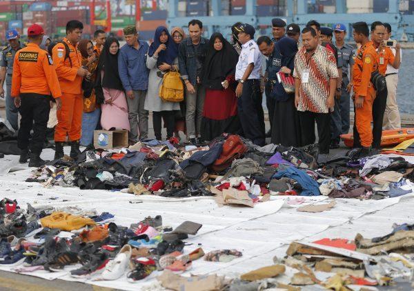 Relatives of passengers of a crashed Lion Air jet check personal belongings retrieved from the waters where the airplane is believed to have crashed, at Tanjung Priok Port in Jakarta, Indonesia, on Oct. 31, 2018. (Tatan Syuflana/AP)