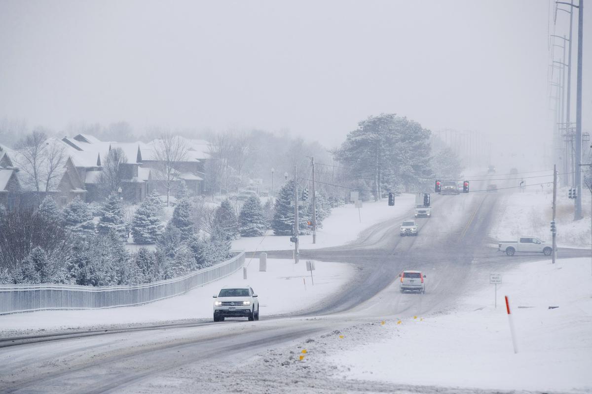 Traffic moves along Pacific Street near its intersection with 189th Street as snow falls in Omaha, Neb., Saturday, Jan. 12, 2019. A massive winter snowstorm moved into Kansas and Nebraska from the Rockies on Friday, then east into Missouri, Iowa, Illinois and Indiana, covering roads and making driving dangerous. (Ryan Soderlin/Omaha World-Herald via AP)