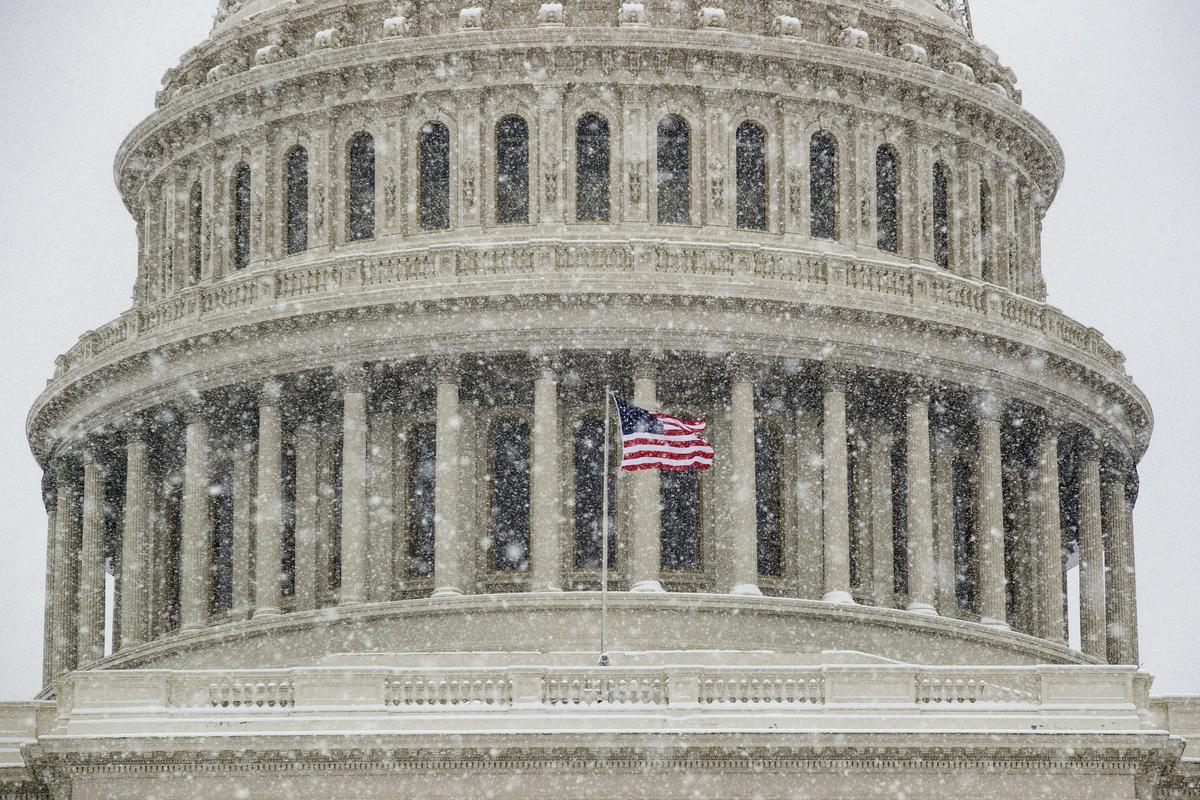An American flag waves in front of the U.S. Capitol Dome as a winter storm arrives in the region Sunday, Jan. 13, 2019, in Washington. (AP Photo/Alex Brandon)
