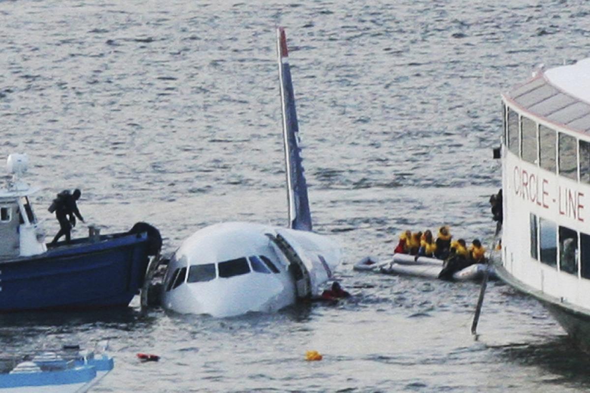 A diver (L), aboard an NYPD vessel, prepares to rescue passengers that escaped from the Airbus 320 US Airways aircraft that made an emergency landing in the Hudson River in New York in what came to be known as the "Miracle on the Hudson" because everyone survived. (Bebeto Matthews/AP Photo)