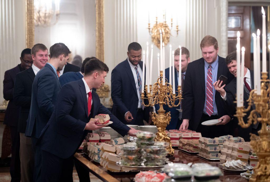 Guests select fast food that the US president purchased for a ceremony honoring the 2018 College Football Playoff National Champion Clemson Tigers in the State Dining Room of the White House in Washington, on Jan. 14, 2019.  (Saul Loeb/AFP/Getty Images)