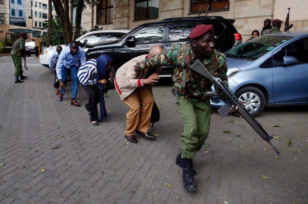 People are evacuated by a member of security forces at the scene where explosions and gunshots were heard at the Dusit hotel compound, in Nairobi, Kenya, Jan. 15, 2019. (Reuters/Baz Ratner)