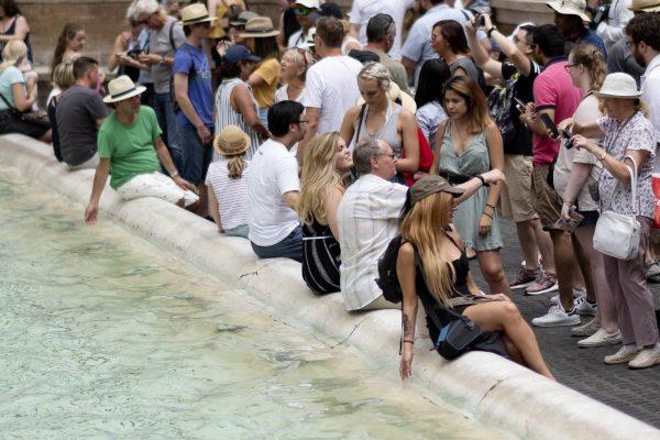 Tourists cool themselves in the water of the Trevi Fountain in central Rome on July 14, 2018. (Andreas Solaro/ AFP)