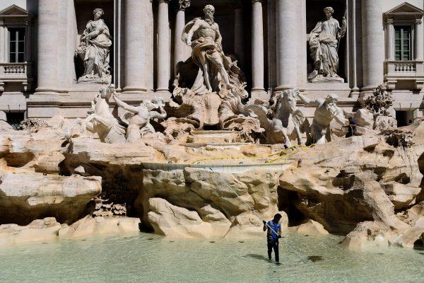 A worker collects coins in the Trevi Fountain during the usual monthly cleaning in Rome on May 2, 2017. (Alberto PizzolI/AFP/Getty Images)