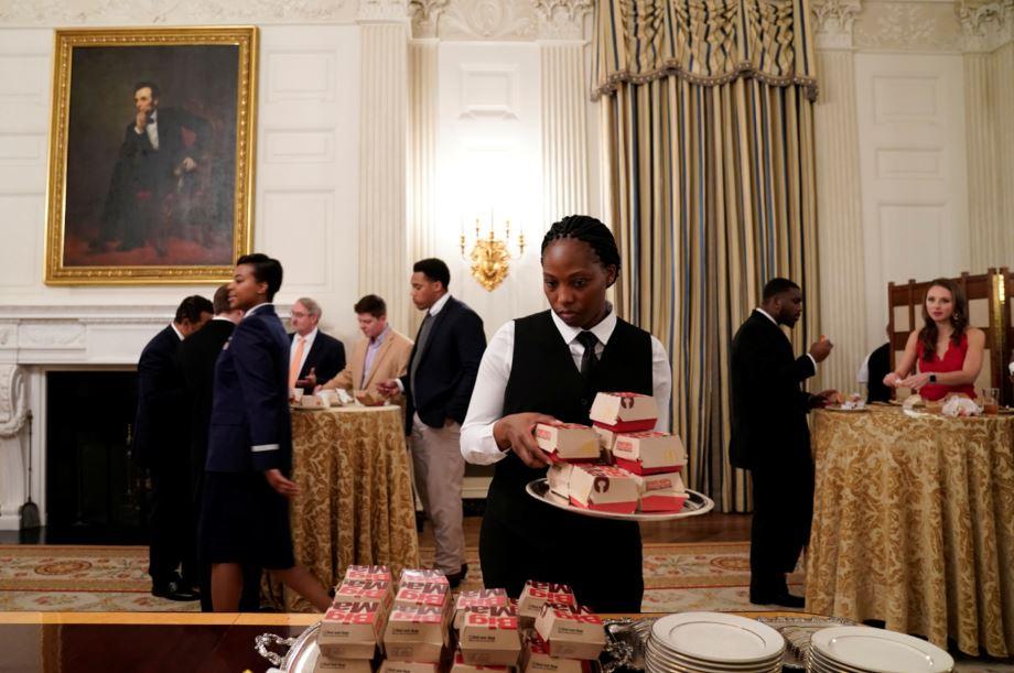 A server places fast food hamburgers provided due to the partial government shutdown as the 2018 College Football Playoff National Champion Clemson Tigers are welcomed in the State Dining Room of the White House in Washington, U.S., January 14, 2019. (Joshua Roberts/Reuters)