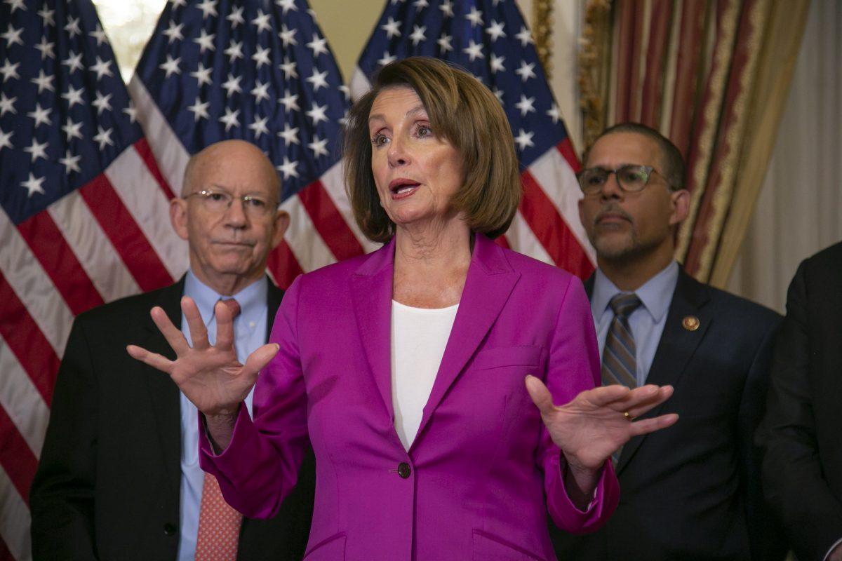 Speaker of the House Nancy Pelosi (D-Calif.), flanked by Rep. Peter DeFazio (D-Ore.), left, and Rep. Anthony Brown, (D-Md.), talks to reporters after signing a House-passed bill requiring that all government workers receive retroactive pay after the partial shutdown ends, at the Capitol in Washington on Jan. 11, 2019. (J. Scott Applewhite/AP)