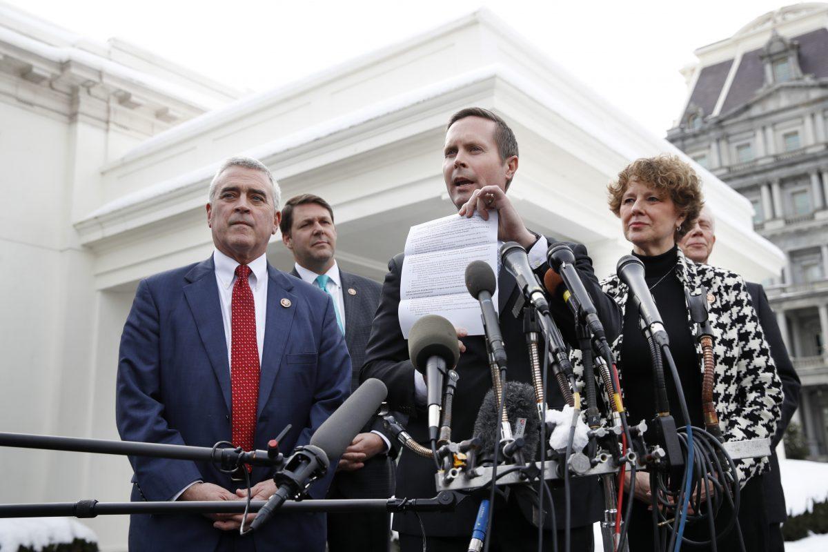 Rep. Rodney Davis, (R-Ill.), center, holds up a paper about President Donald Trump's proposals for the border, as he and other House Republicans speak to the media, Tuesday, Jan. 15, 2019, after meeting with the president at the White House on border security. (AP Photo/Jacquelyn Martin)