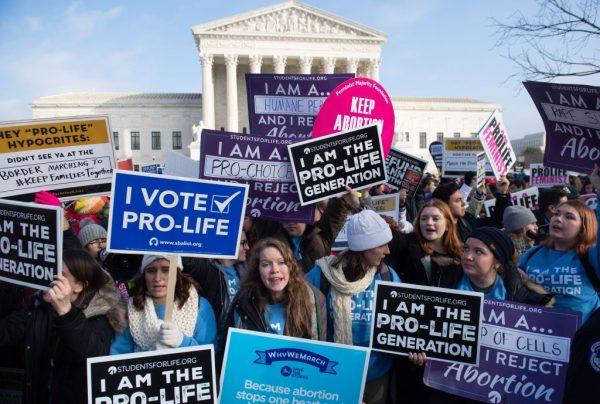 Pro-choice activists hold signs in response to anti-abortion activists participating in the "March for Life," an annual event to mark the anniversary of the 1973 Supreme Court case Roe v. Wade, which legalized abortion in the United States, outside the U.S. Supreme Court in Washington on Jan. 18, 2019. (Saul Loeb/AFP/Getty Images)