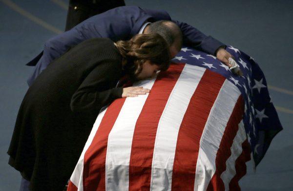 Lupe Corona and Merced Corona kiss the flag-draped coffin of their daughter, Davis Police Officer Natalie Corona, during funeral services for Natalie Corona at the University of California-Davis, in Davis, Calif., on Jan. 18, 2019. (Rich Pedroncelli, Pool/AP)